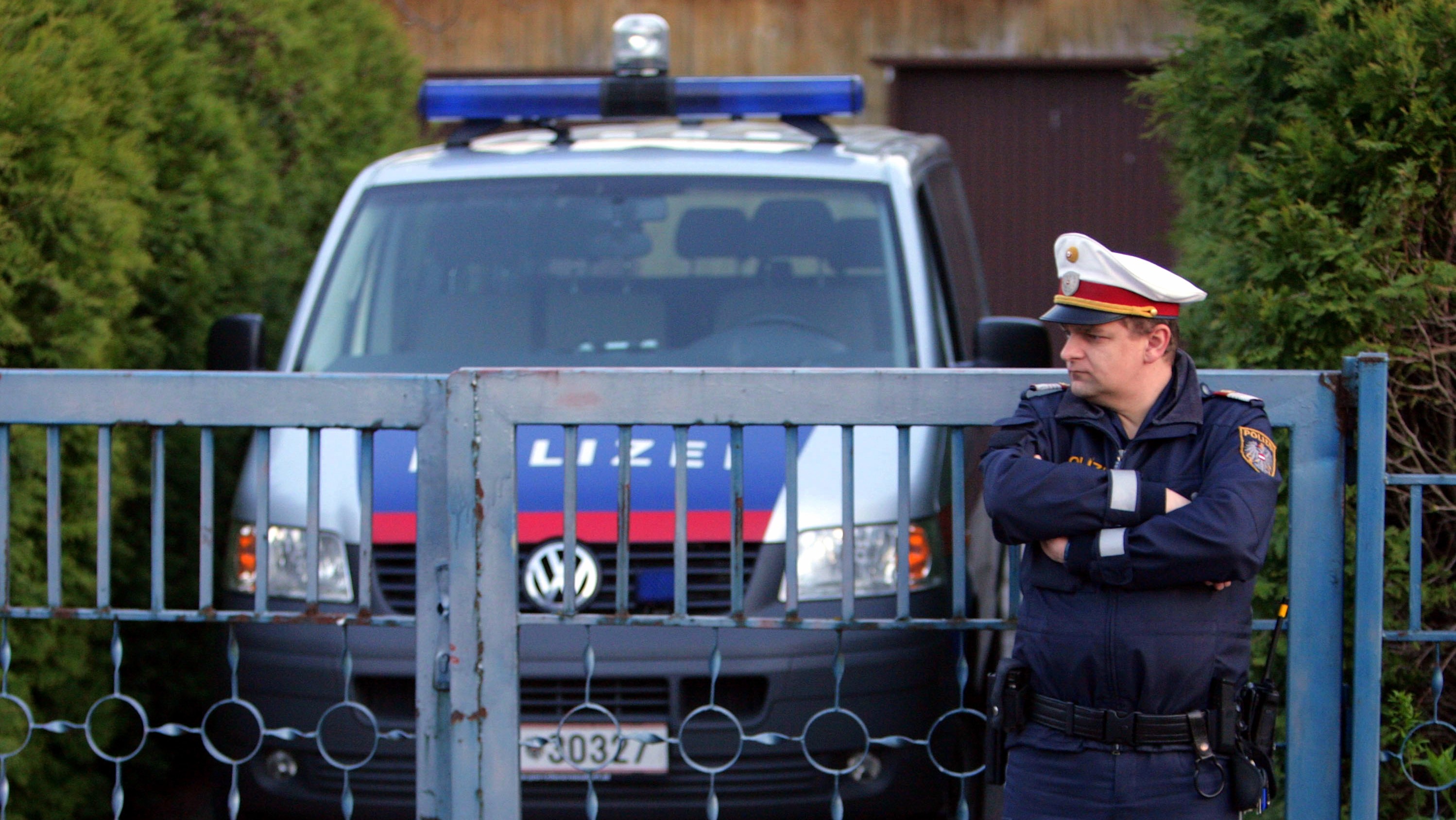 Polícia_Rakúsko_policajt pred domom_ilustračné foto_podozriví